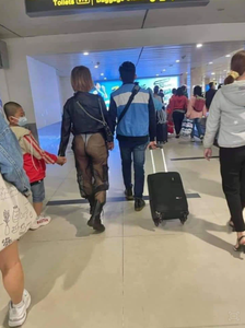 Người phụ nữ mặc quần xuyên thấu để lộ nguyên vòng 3 thản nhiên đi lại giữa sân bay cùng chồng và con nhỏ